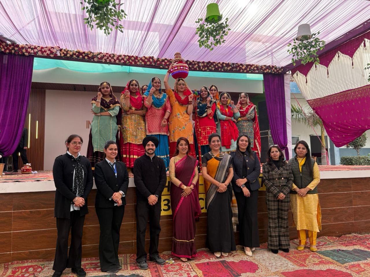 Students in traditional attire with staff at a cultural function