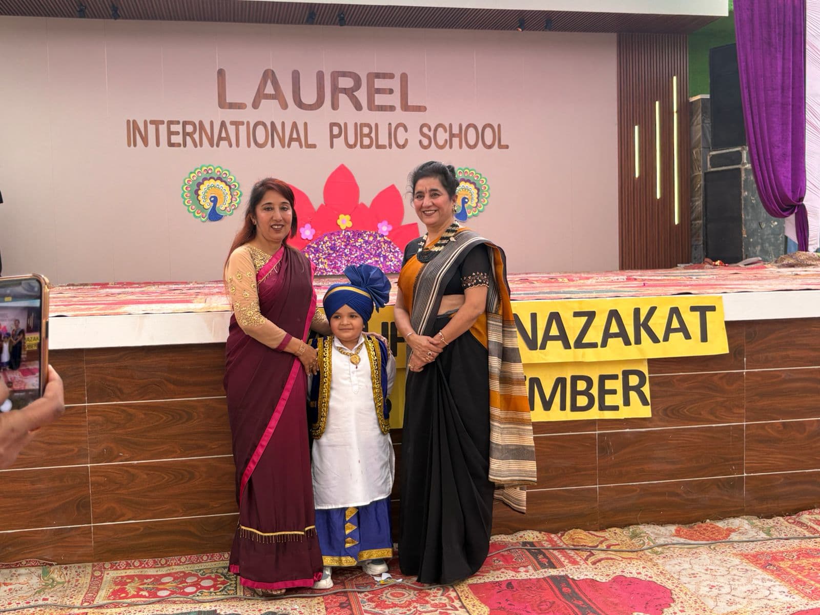 Students and staff on stage at a Laurel Day function, Laurel International Public School