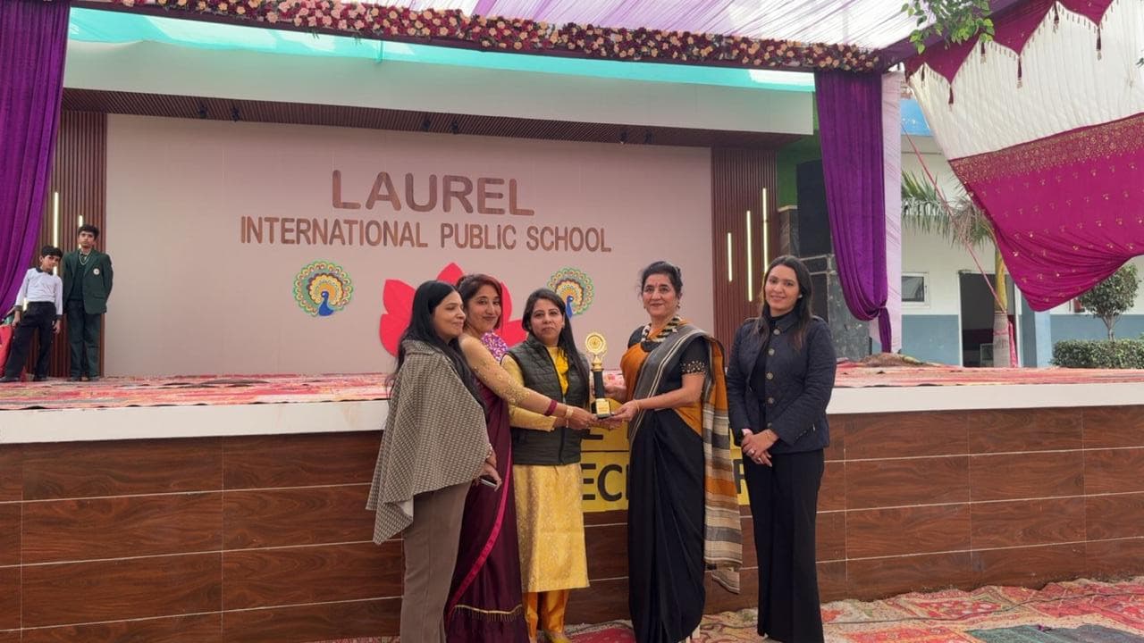 Staff receiving a trophy on stage at a school function