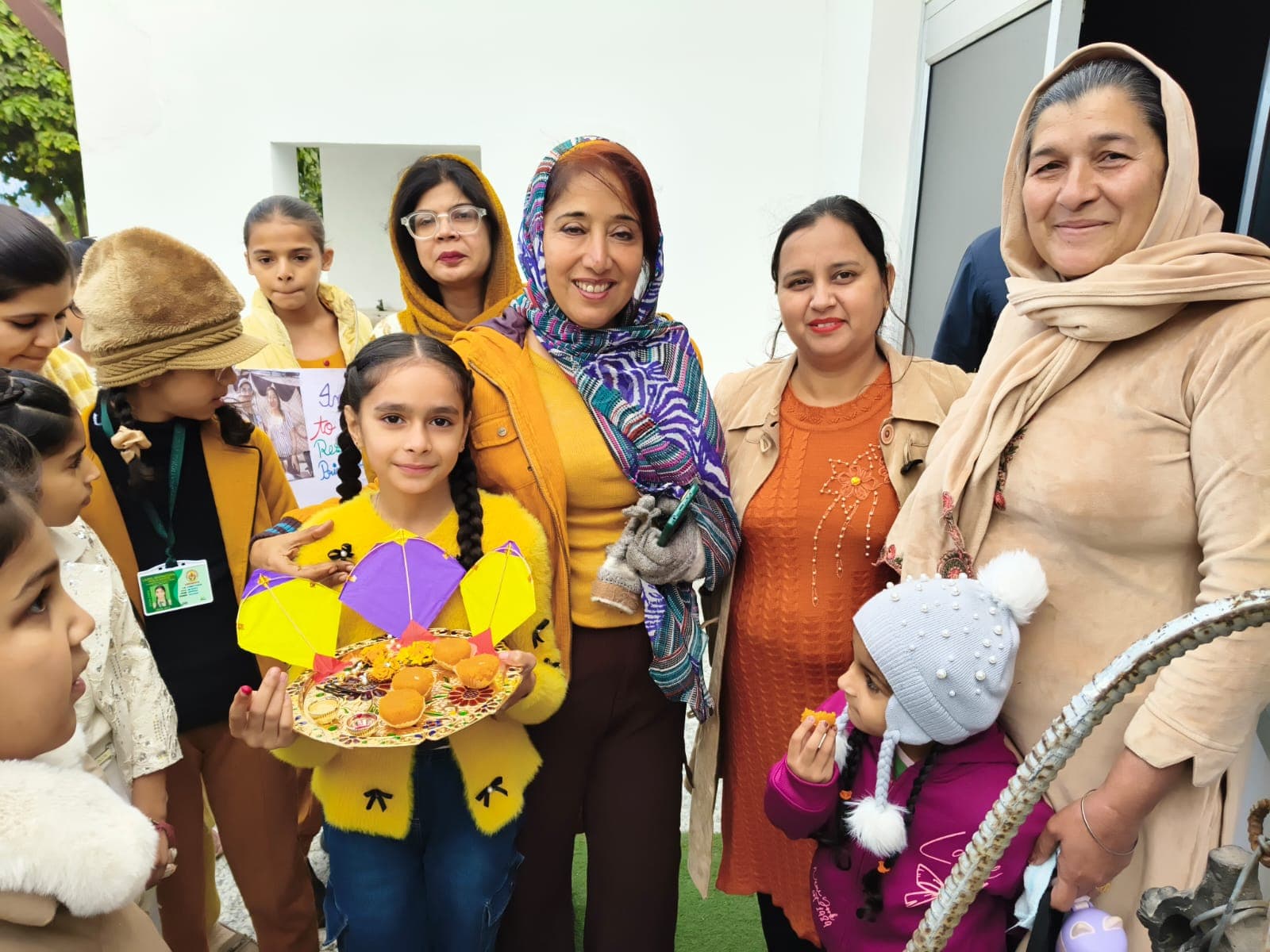 Students and staff with kites and sweets during a winter festival