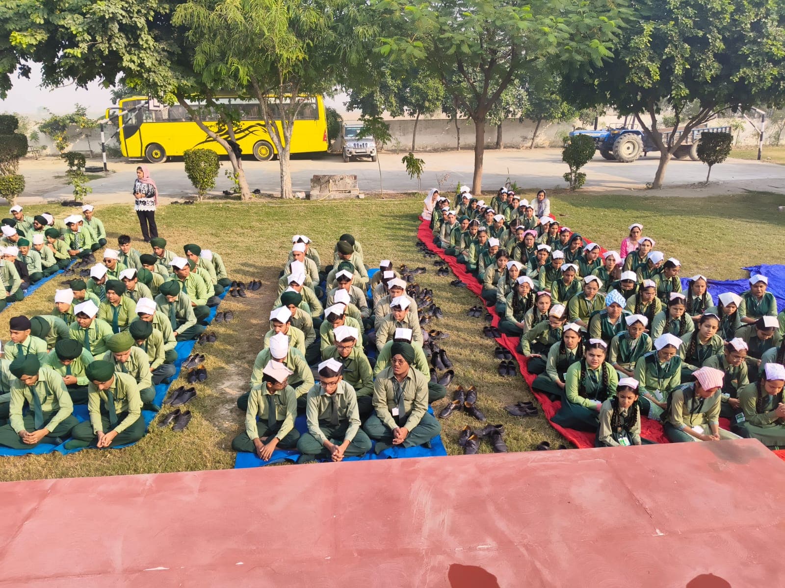 Students seated in rows on the lawn for an outdoor assembly